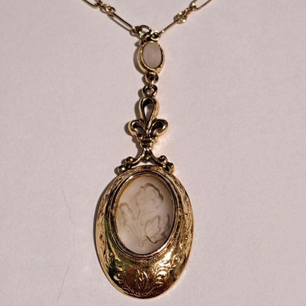 1928 brand gold tone necklace with a rose design etched in pendant